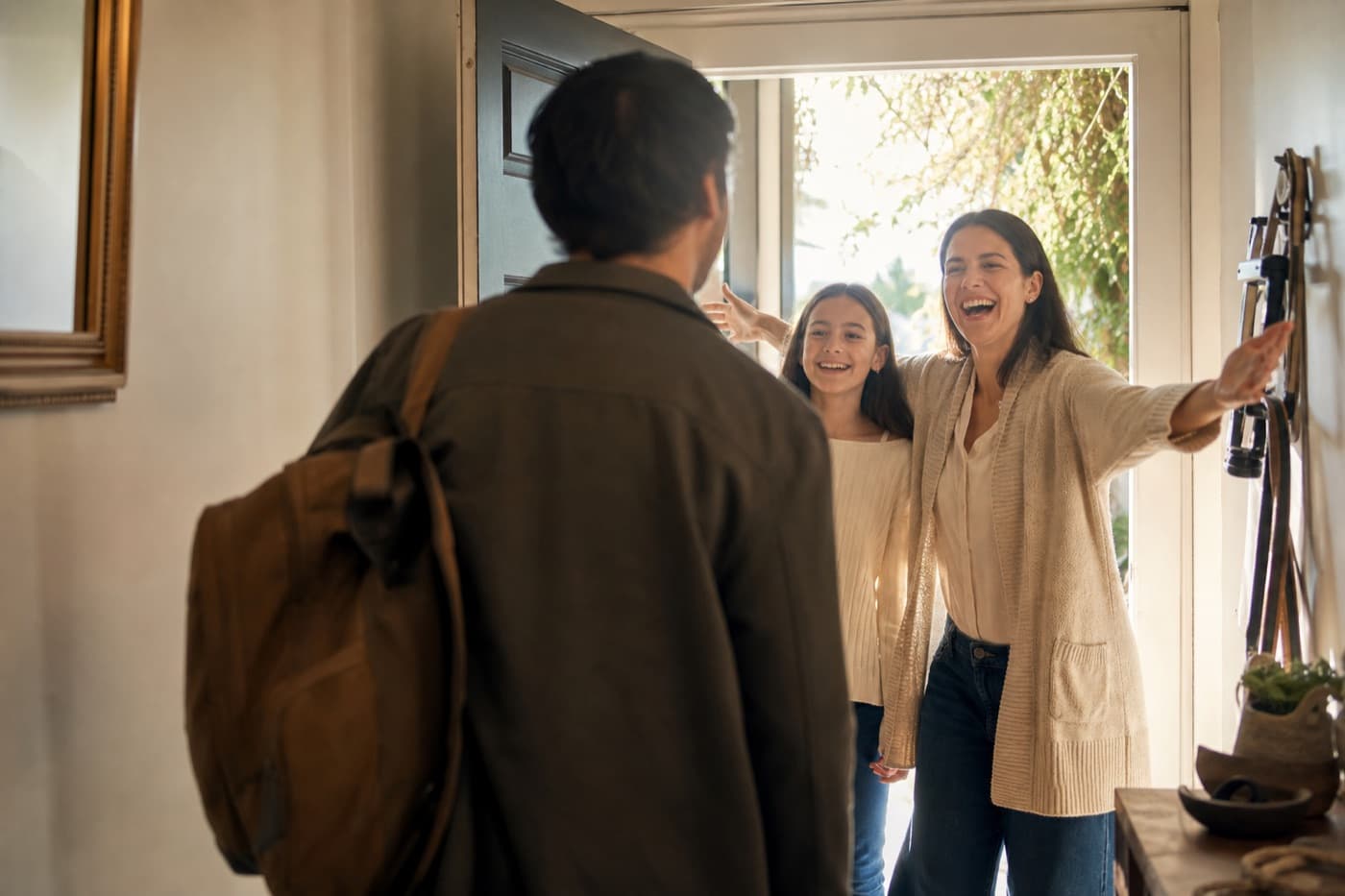 A visitor welcomed at the front door of a bright home