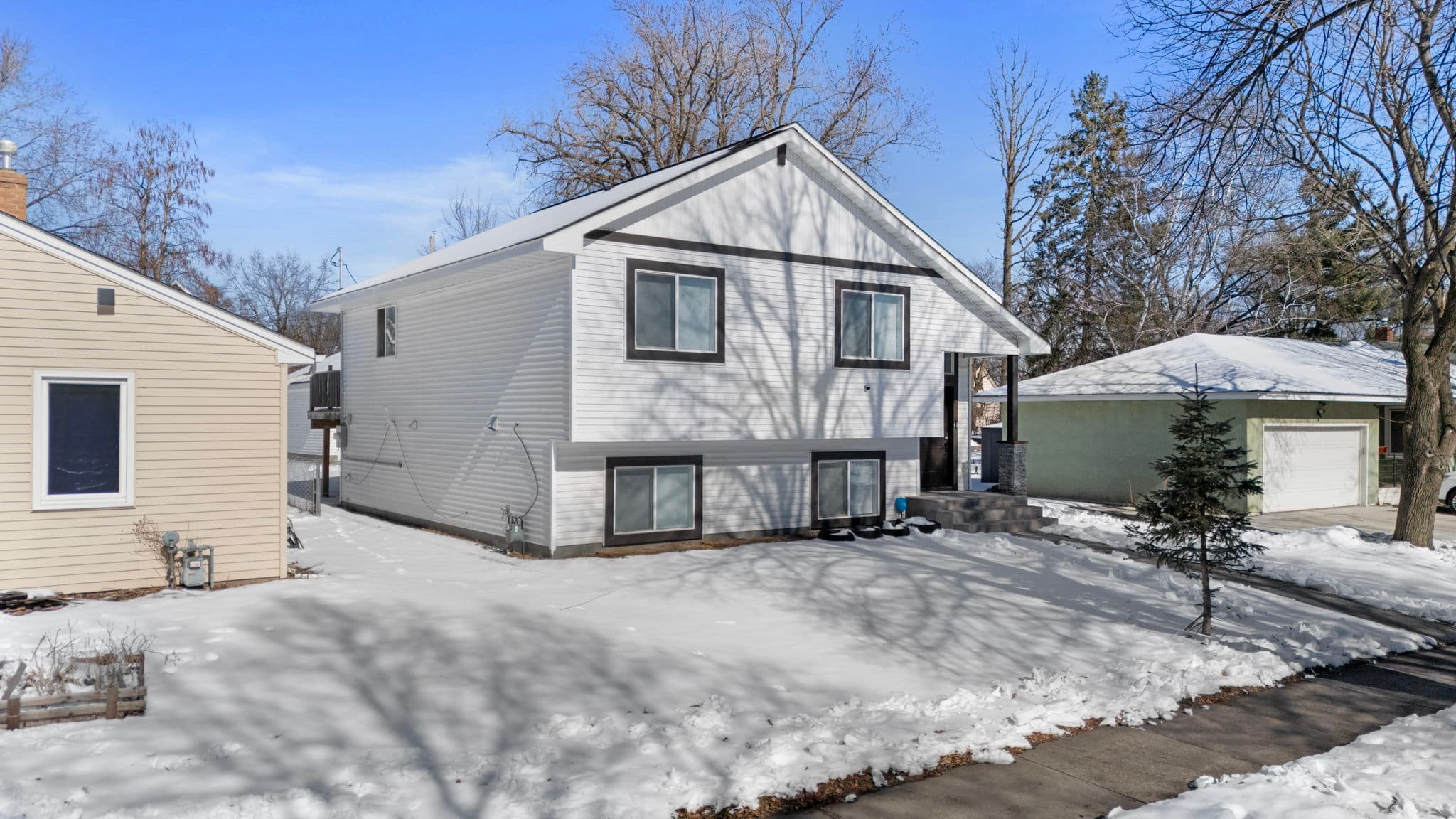 Angled front-corner view of the home with dark window trim